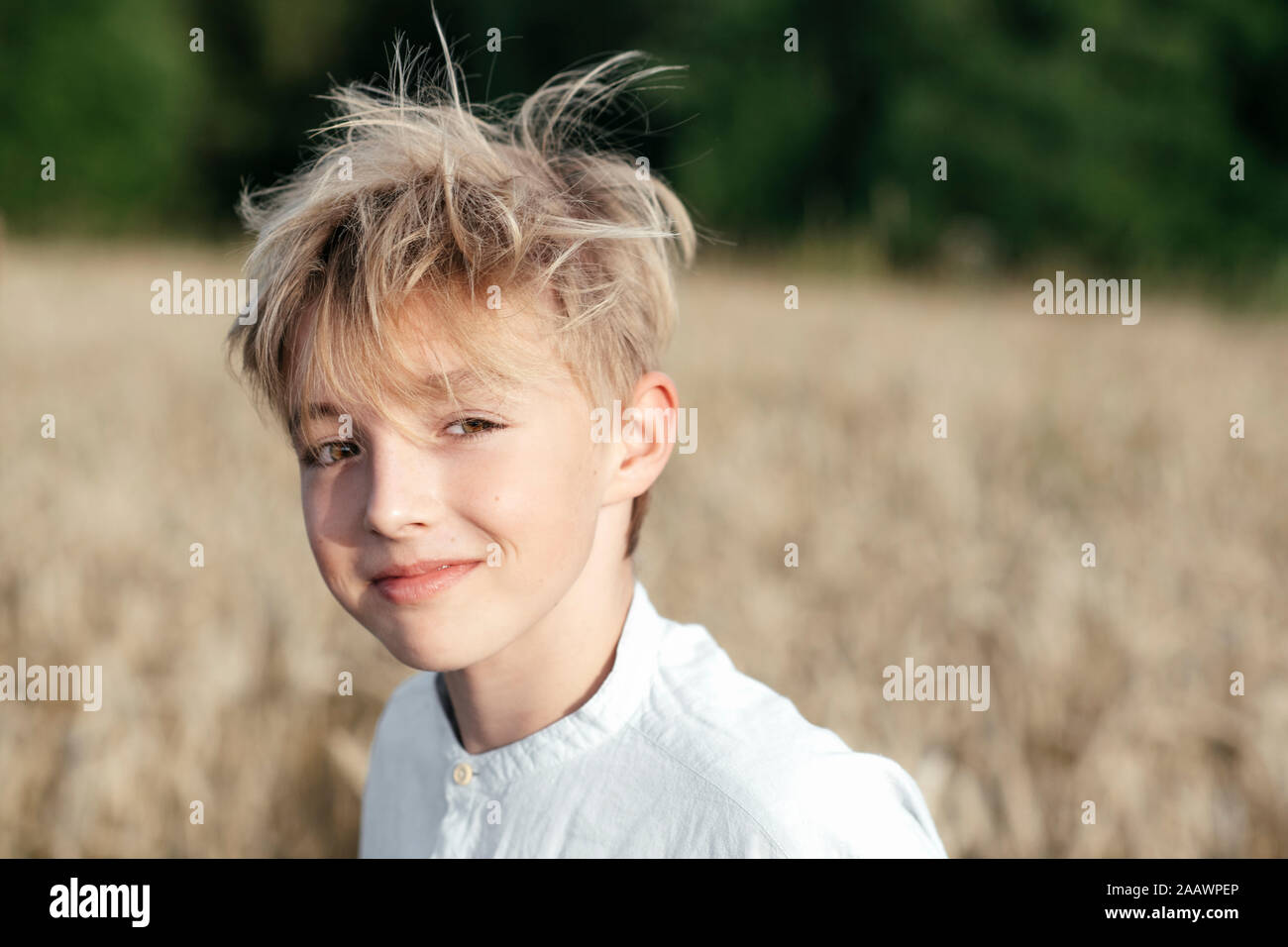 Ritratto di sorridente ragazzo biondo in un campo di avena Foto Stock