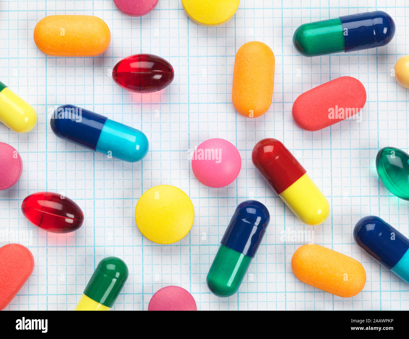 Angolo di alta vista di vari farmaci colorati su un foglio di carta millimetrata Foto Stock