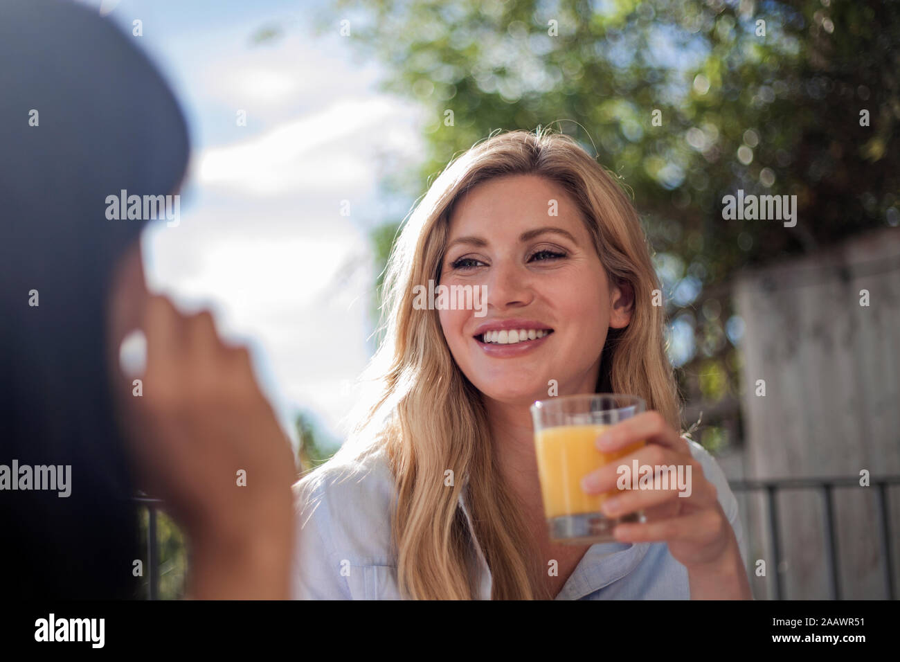 Due donne di fare colazione in outdoor cafe tabella, divertendosi, parlando Foto Stock