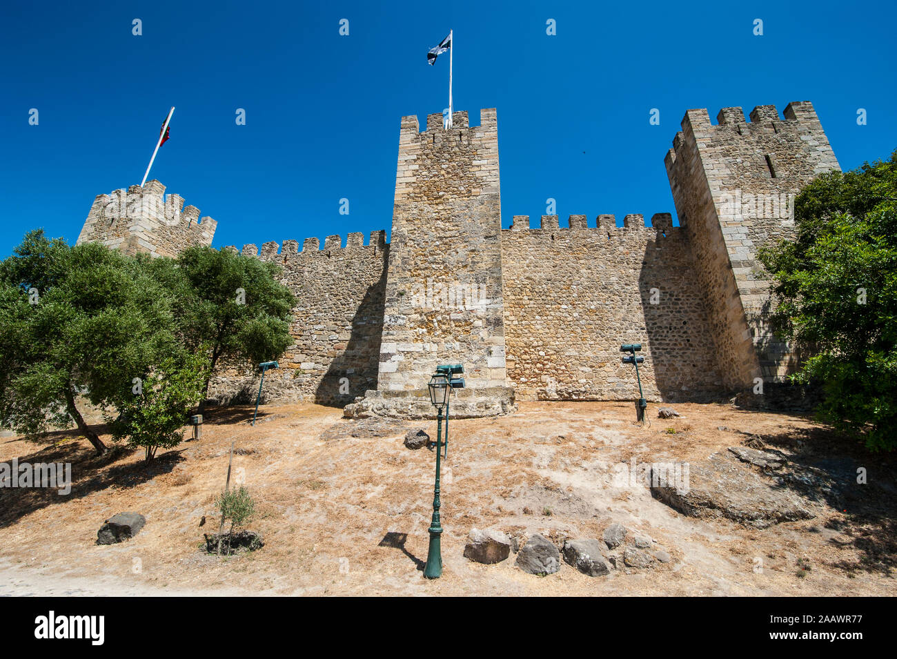 Basso angolo vista delle mura fortificate di Castelo Sao Jorge contro il cielo blu chiaro, Lisbona, Portogallo Foto Stock