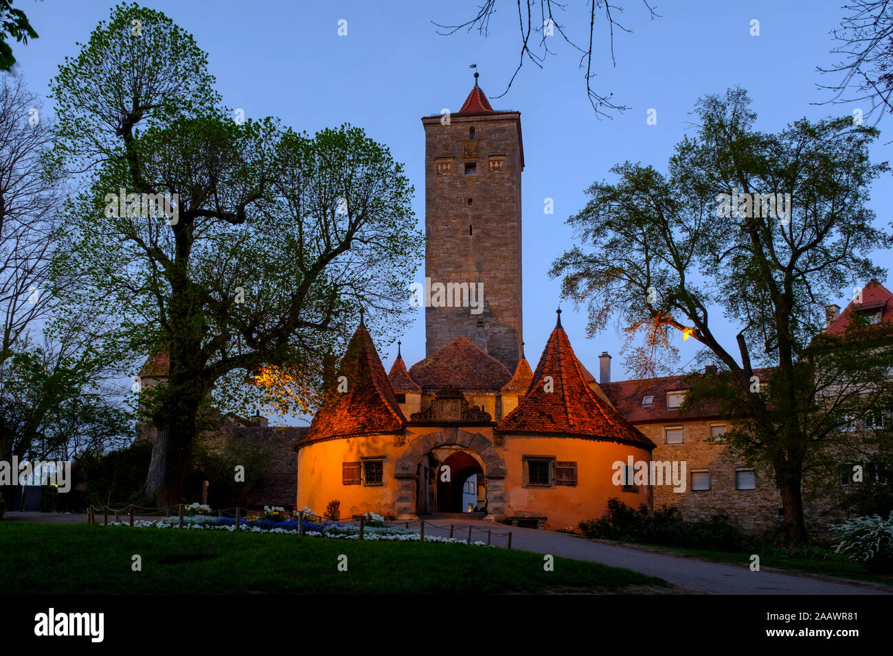 Basso angolo vista della città illuminata hall torre in Rothenburg contro il cielo chiaro, Germania Foto Stock