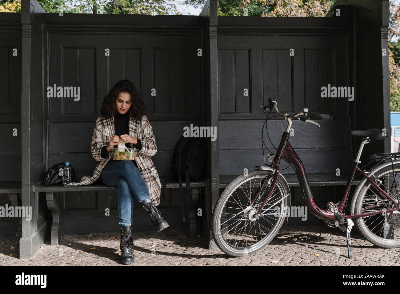 Donna con bicicletta avente la pausa pranzo sulla piattaforma della stazione, Berlino, Germania Foto Stock