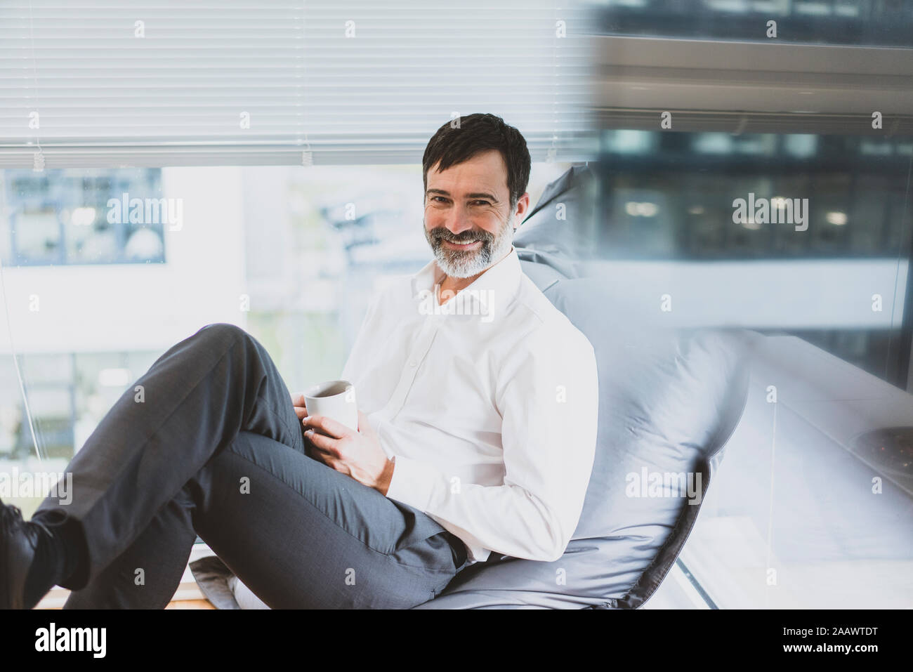 Ritratto di sorridente imprenditore maturo avente una pausa caffè Foto Stock