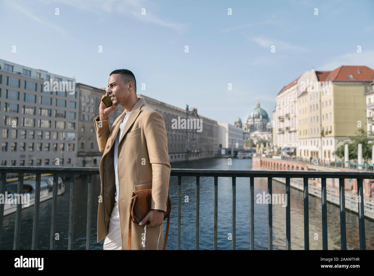 Uomo d affari al telefono in piedi su un ponte di Berlino, Germania Foto Stock