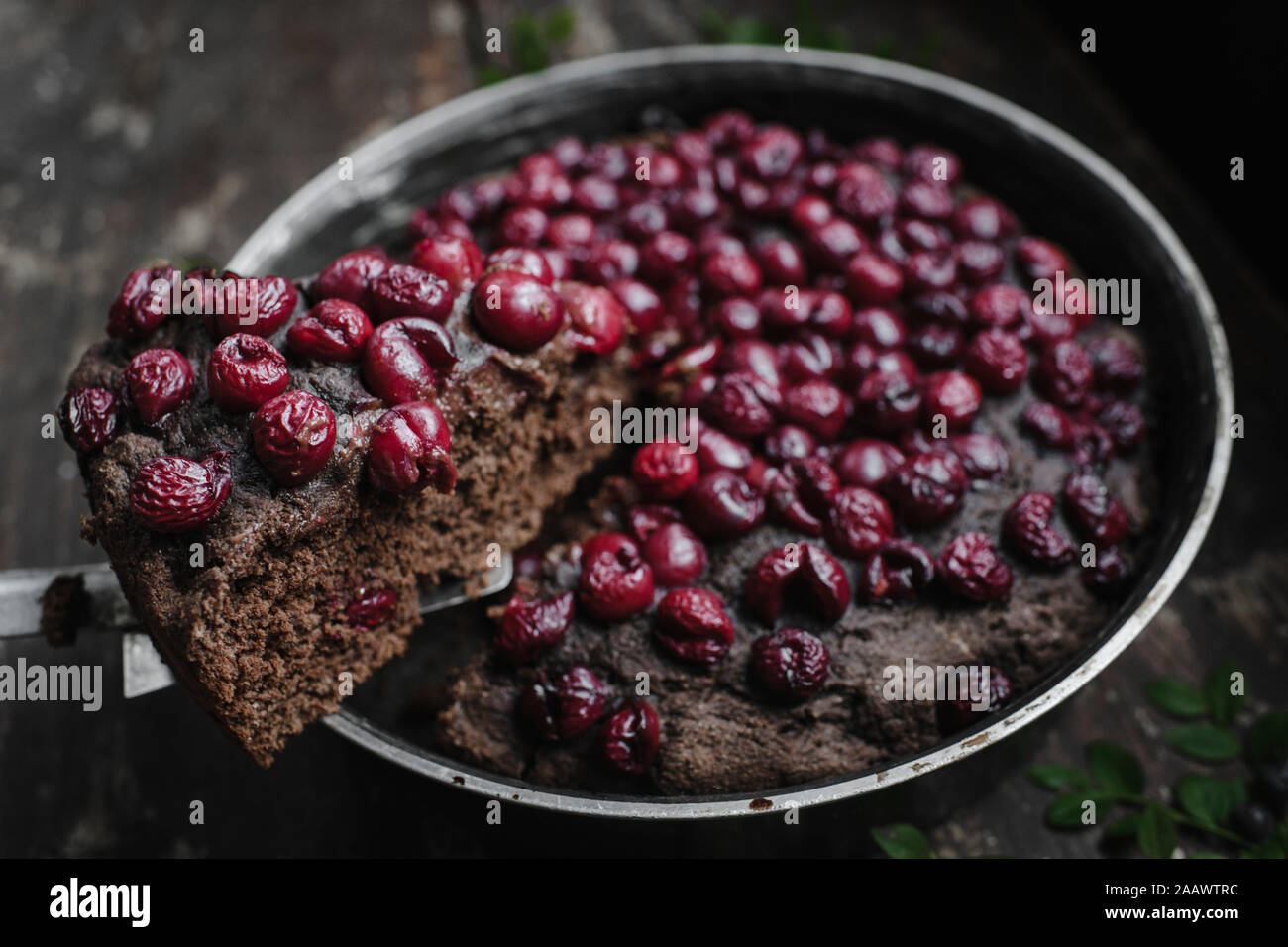 Close-up di ciliegia brownie fetta di torta oltre il contenitore sul tavolo Foto Stock