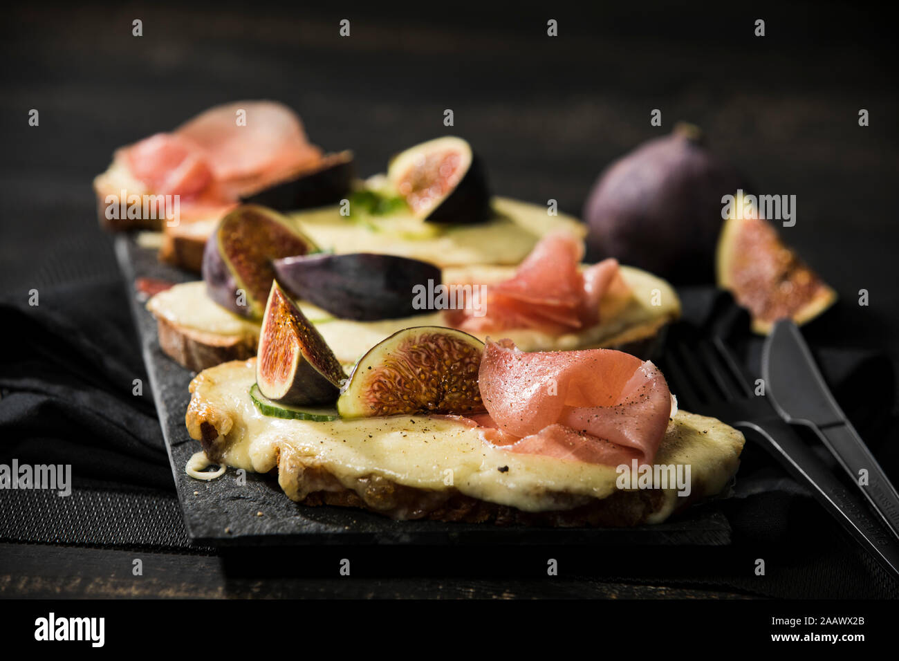 Close-up di formaggio cotto il pane con la figura e prosciutto serviti al tavolo Foto Stock