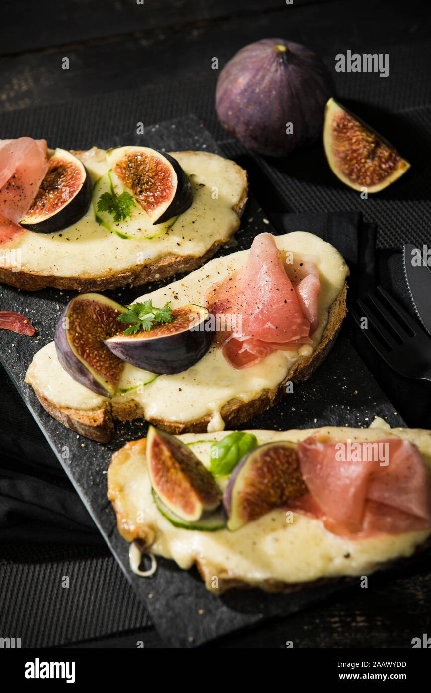 Close-up di formaggio cotto il pane con la figura 4 fette di prosciutto e serviti al tavolo Foto Stock