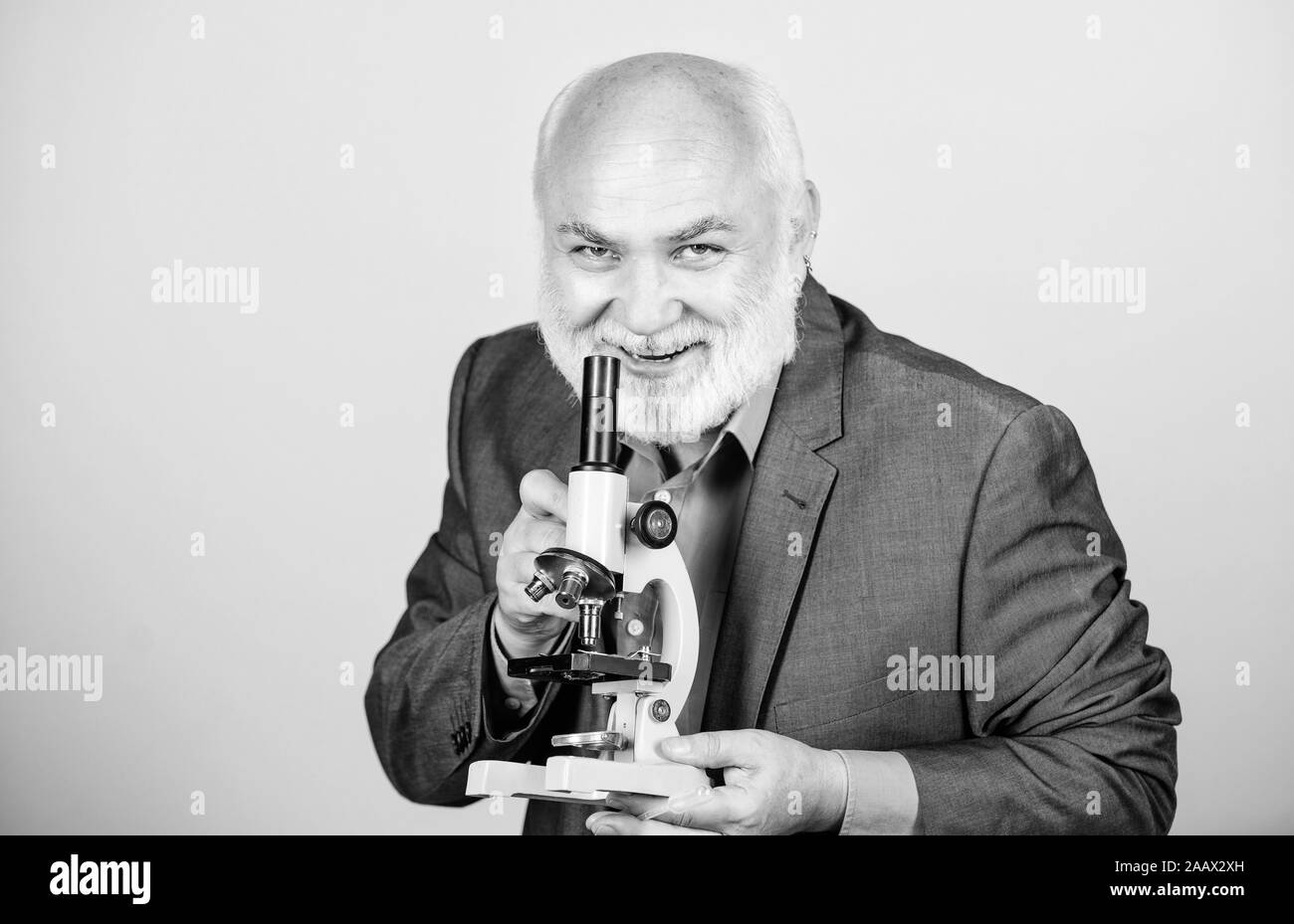 La scienza comporta la teoria della conoscenza e della saggezza. biologia istruzione. scienza lab. chimica in laboratorio scolastico. maturo maestro barbuto con microscopio. senior biologo uomo. professore universitario. Foto Stock