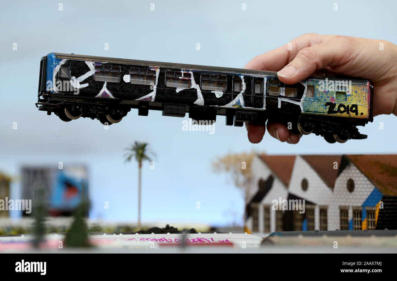 Una vista di una carrozza ferroviaria dipinta dal pittore Goldie che è parte di Urban miniature, una mostra di un modello del villaggio di ferrovia e dipinta da quaranta dei migliori urban artisti contemporanei attualmente mostra in Brighton, Sussex. Foto Stock