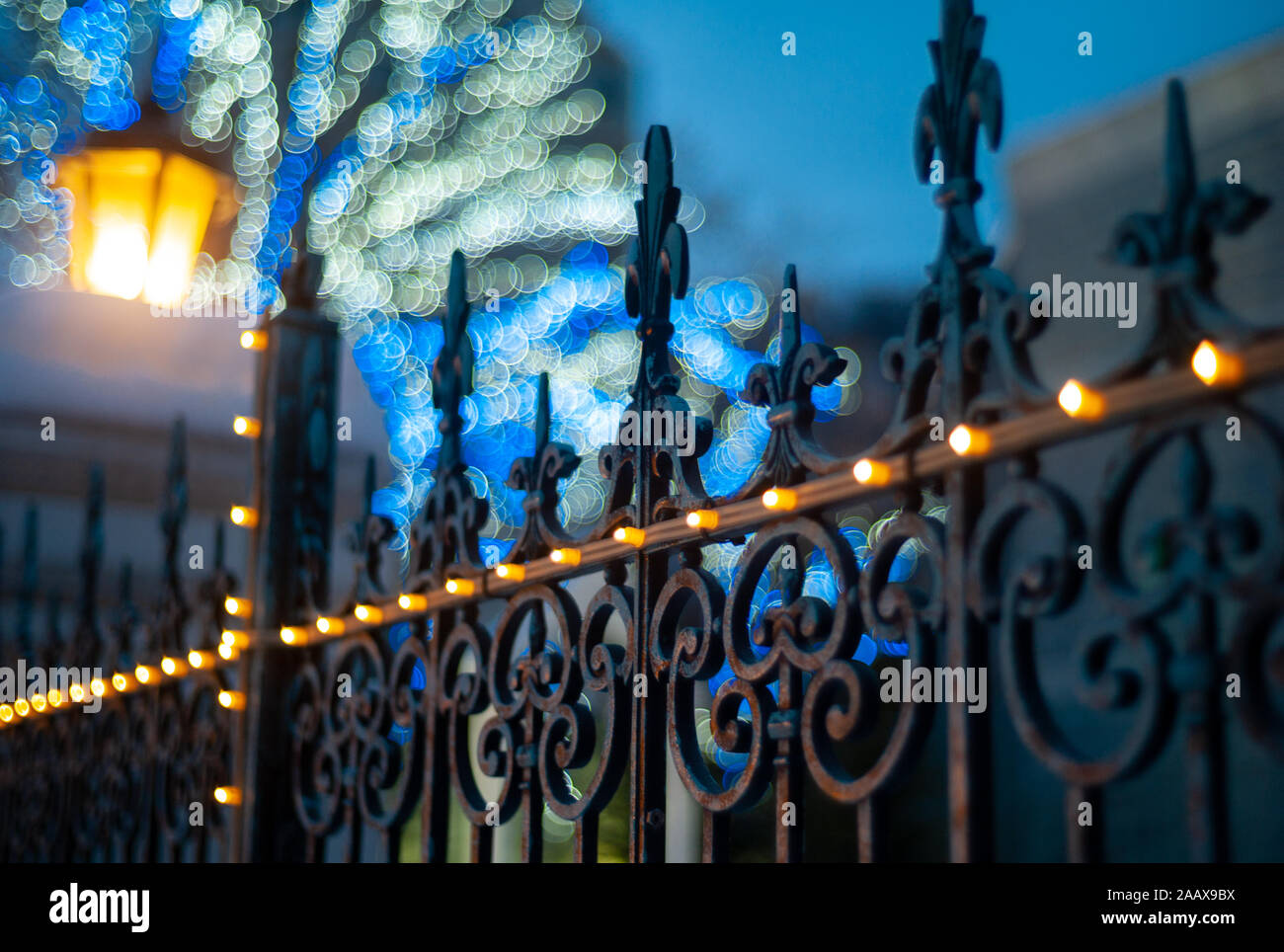 FLEUR de lis di ferro, recinzione di giglio francese e lanterna gialla con fondo corpo blu. Foto Stock