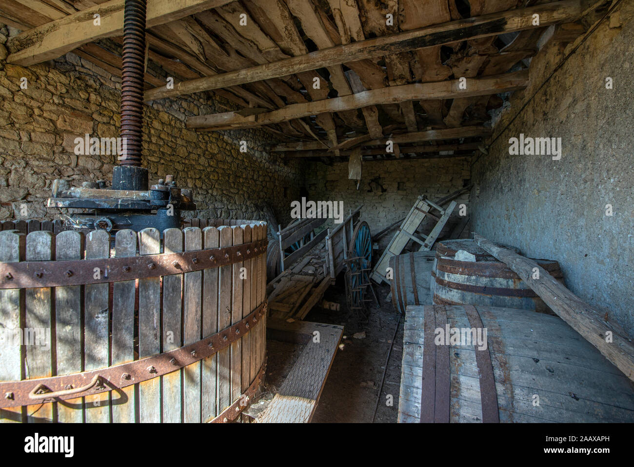 Periodo abbandonati vino premere e per le attrezzature agricole in un vecchio fienile francese. Foto Stock
