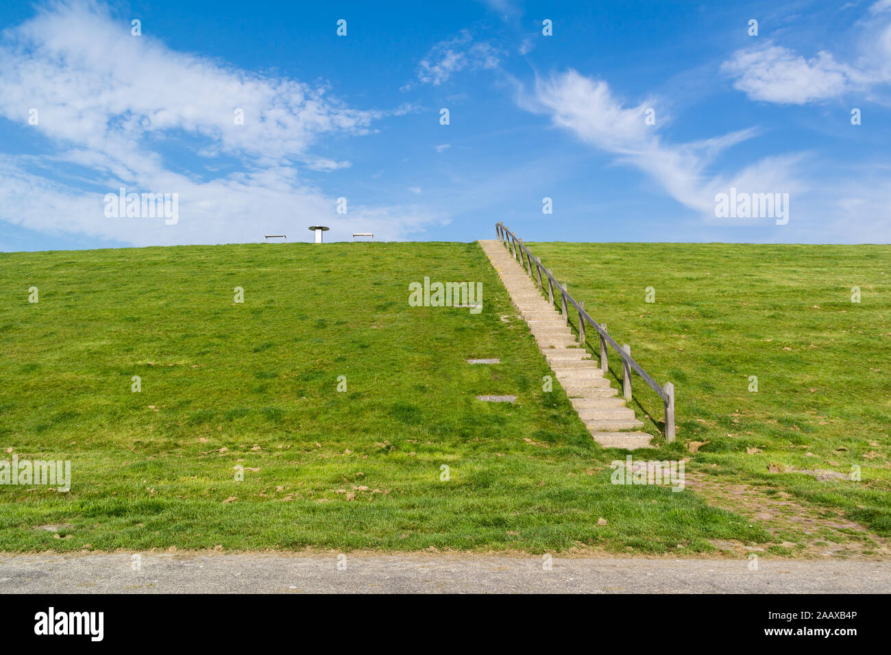 Scala di accesso alla parte superiore della diga con tavolo da picnic. Dyke protegge Friesland polder da Waddensea, Paesi Bassi Foto Stock