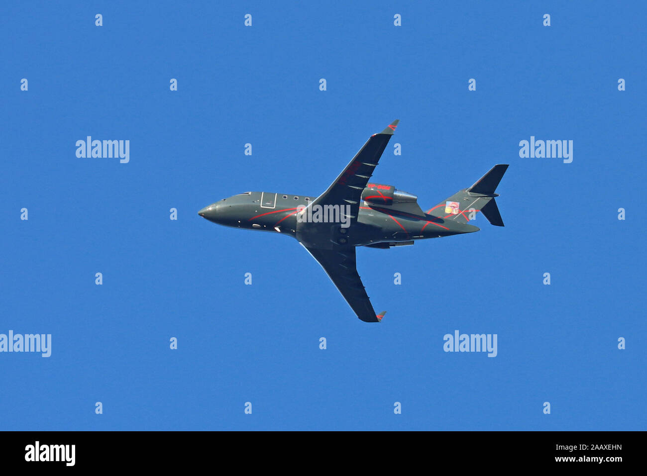 Jet Executive Bombardier Challenger 605 VP-BGM flying overhead, impostare contro un cielo blu sullo sfondo. Foto Stock