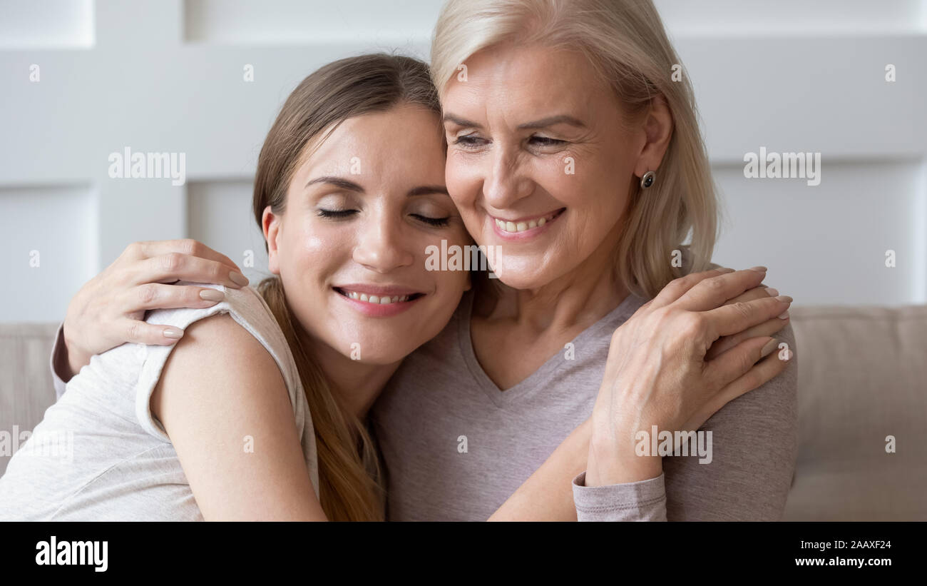 Sorridente pacifica i vecchi pensionati madre abbracciando la calma felice figlia. Foto Stock