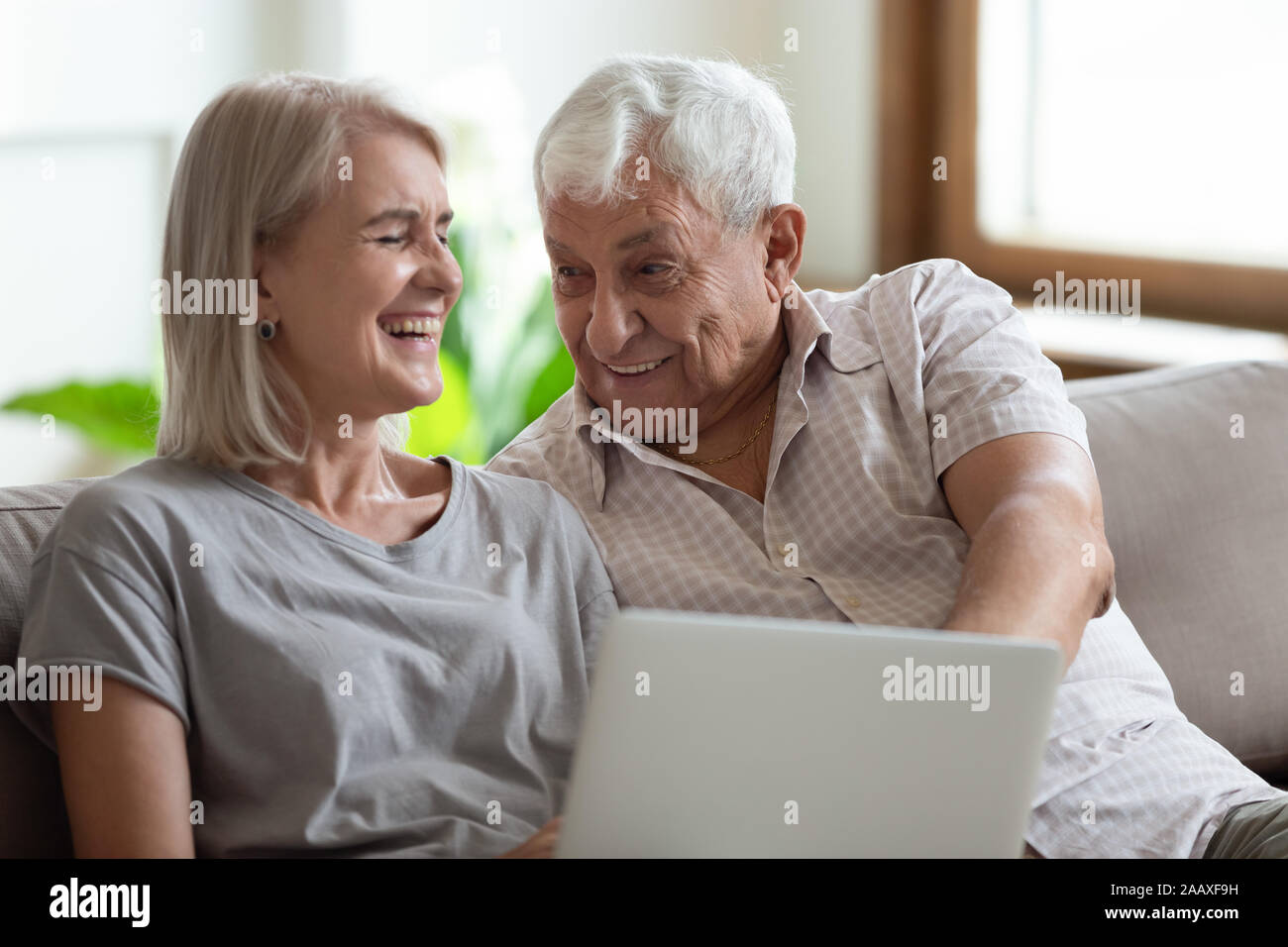 Overjoyed donna matura seduti sul divano con gioiosa uomo anziano. Foto Stock