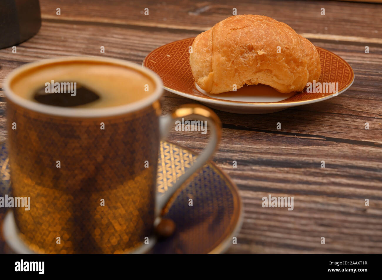 Tazza di caffè e croissant su sfondo di legno. Close up Foto Stock