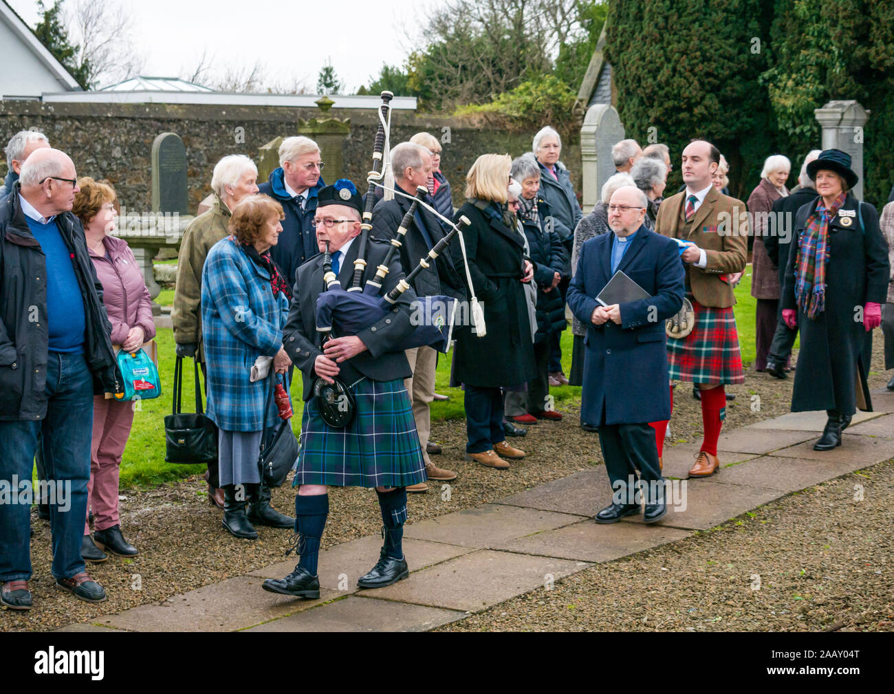 Athelstaneford, East Lothian, Scozia, Regno Unito. Il 24 novembre 2019. Si intraversa Festival: il primo giorno del festival annuale di mark St Andrew's Day avviene nel luogo di nascita della Scottish bandiera nazionale dove la si intraversa apparve nel cielo come un buon auspicio quando il Picts & scozzesi hanno sconfitto i sassoni guidati da Athelstan. Dopo un servizio di chiesa, Haddington Pipe Band piper conduce il ministro & Fraser Thompson della bandiera scozzese fiducia al memoriale di benedire un nuovo si intraversa Foto Stock