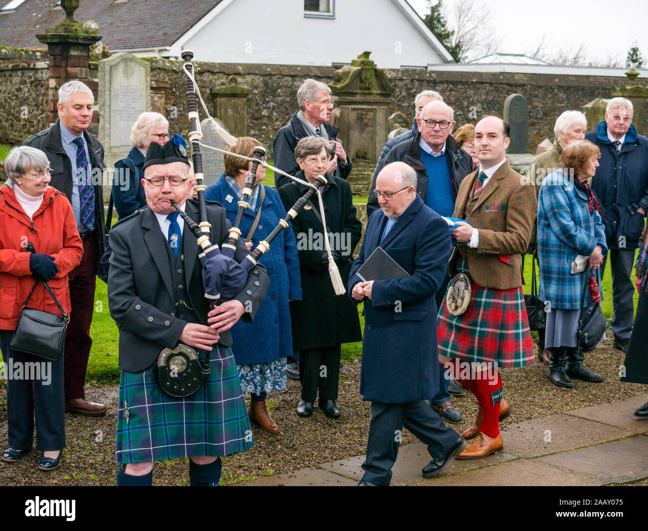 Athelstaneford, East Lothian, Scozia, Regno Unito. Il 24 novembre 2019. Si intraversa Festival: il primo giorno del festival annuale di mark St Andrew's Day avviene nel luogo di nascita della Scottish bandiera nazionale dove la si intraversa apparve nel cielo come un buon auspicio quando il Picts & scozzesi hanno sconfitto i sassoni guidati da Athelstan. Dopo un servizio di chiesa, Haddington Pipe Band piper conduce il ministro & Fraser Thompson della bandiera scozzese fiducia al memoriale di benedire un nuovo si intraversa Foto Stock