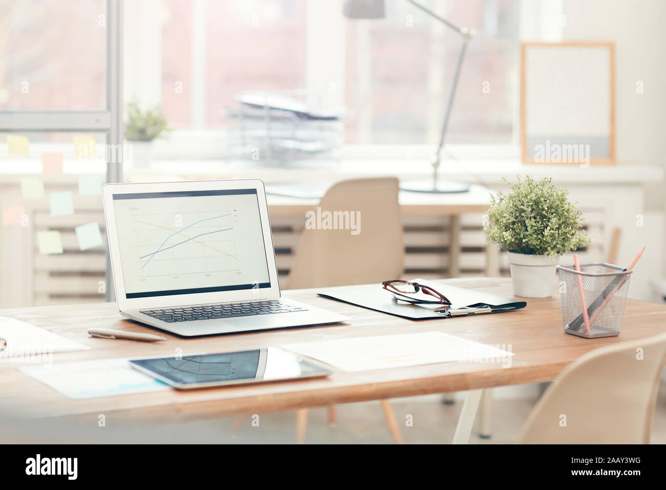 Immagine di sfondo del computer portatile sul tavolo di legno in un ufficio moderno interno, workplace design concept, spazio di copia Foto Stock