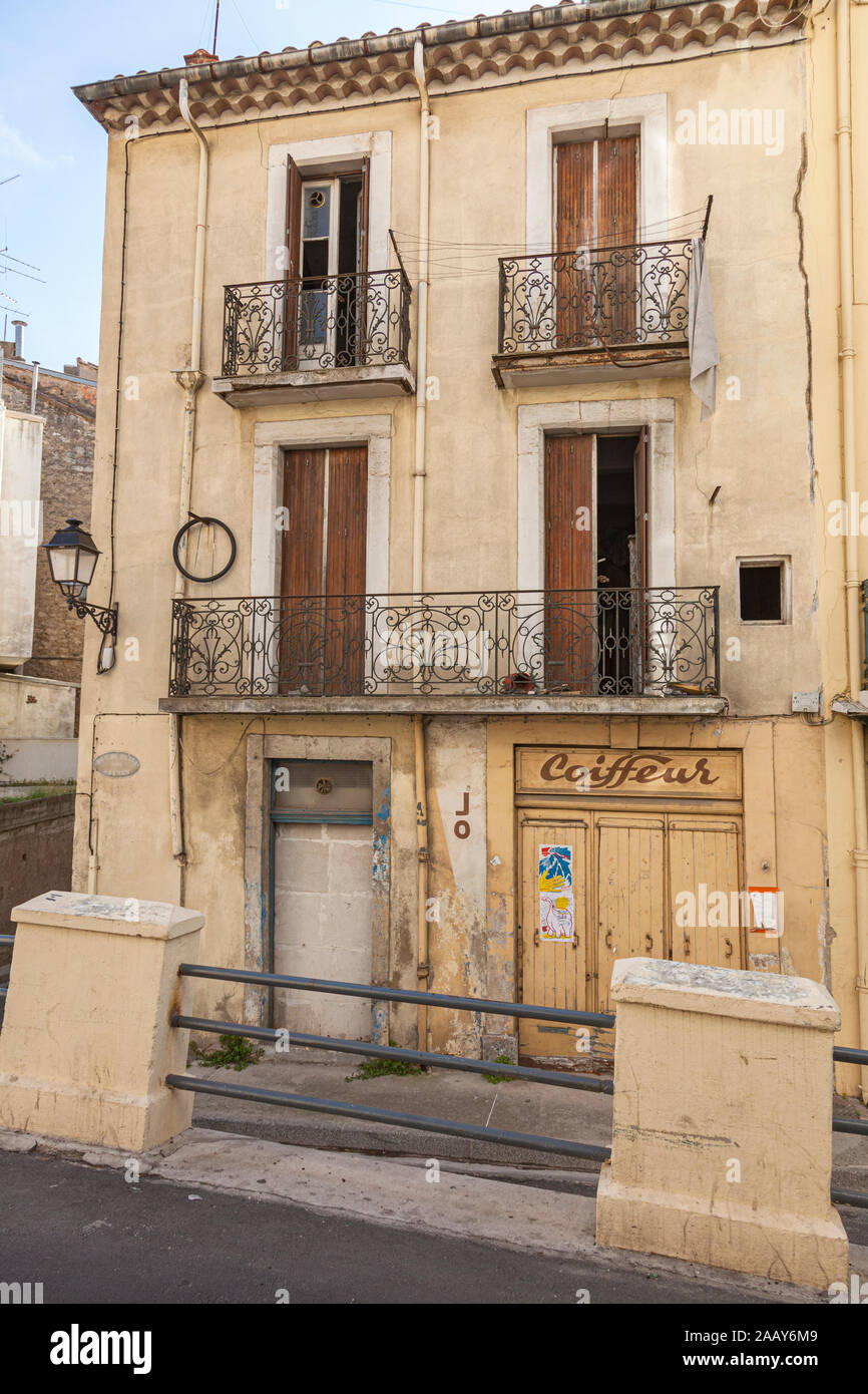 Run-verso il basso edificio con un chiuso parrucchieri business in Beziers, Francia. Foto Stock