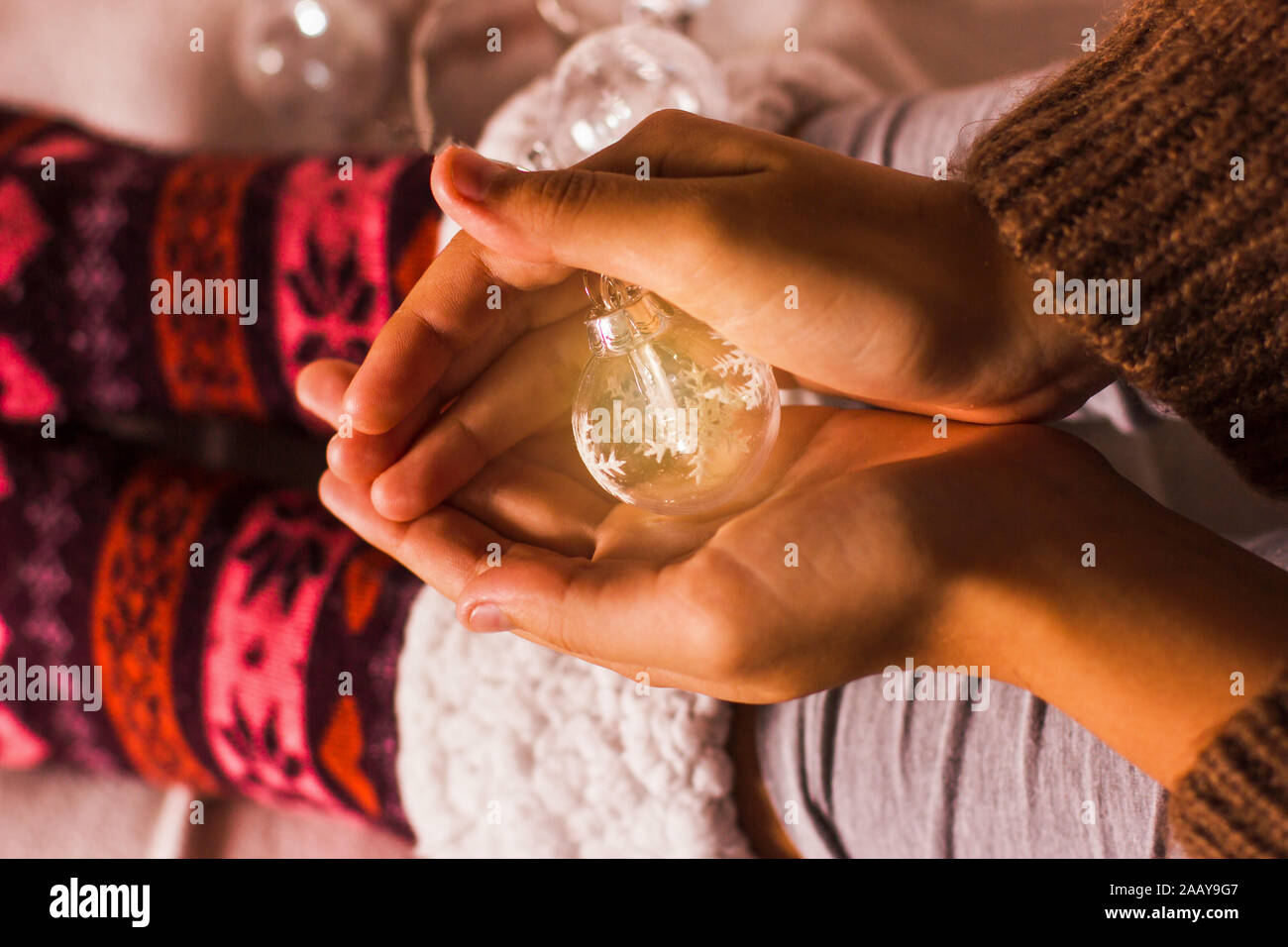 Le luci di Natale nelle ragazze di palme. Accogliente winter concetto. Caldo Calze a maglia Foto Stock