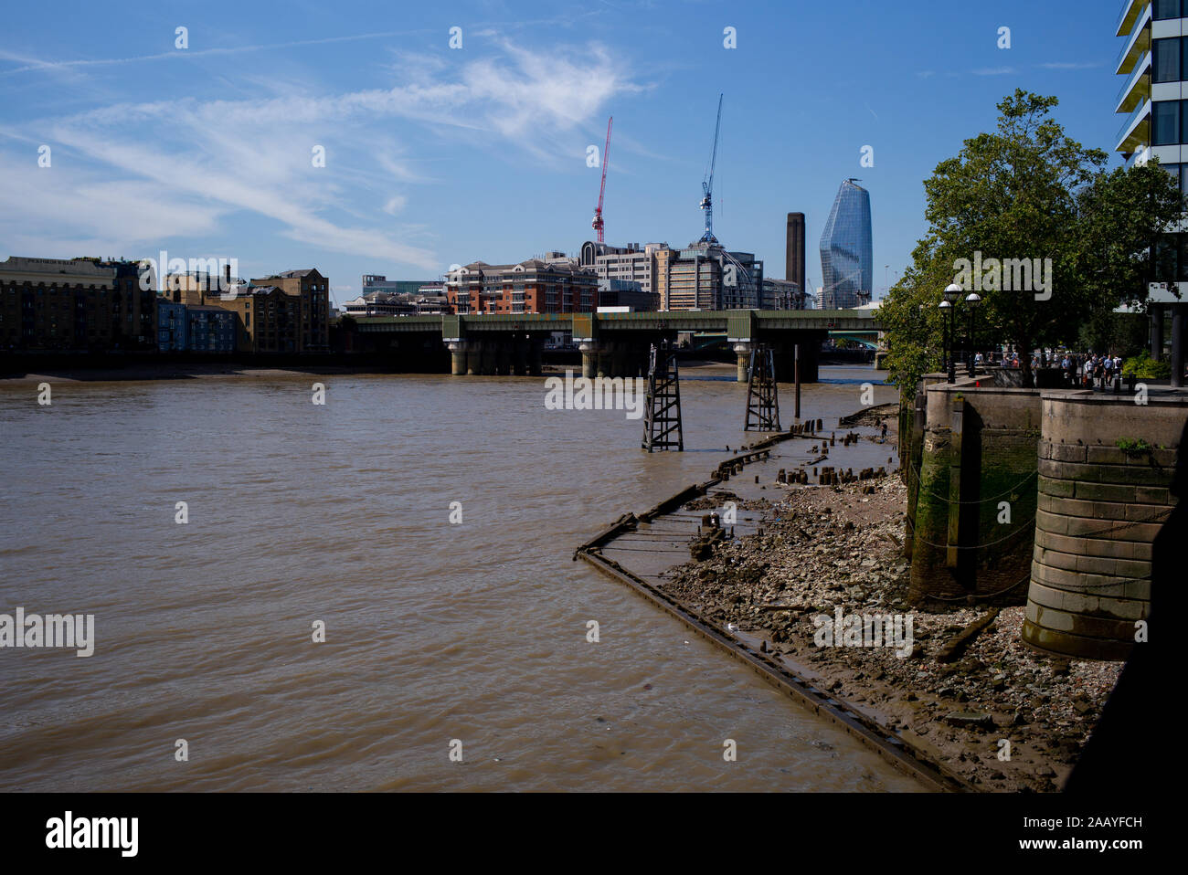 Un paesaggio urbano guardando verso Southwick ponte ferroviario lungo il fiume Tamigi a Londra Inghilterra che mostra il Tamigi a bassa marea accanto alla passeggiata anseatica Foto Stock