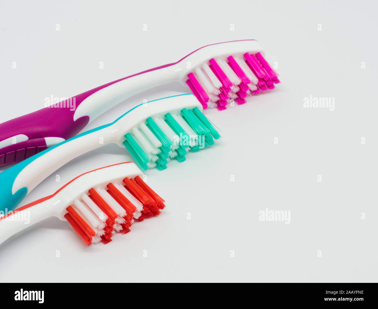 Tre spazzolini da denti su sfondo bianco Foto Stock