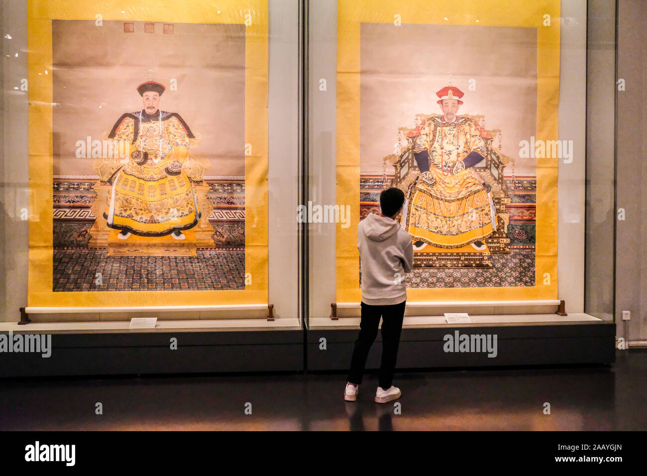 Un museo goer davanti di ritratti della dinastia Qing imperatori in Cina il museo nazionale a Pechino in Cina Foto Stock