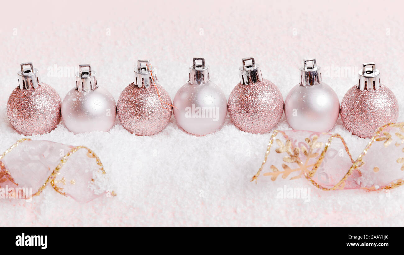 Composizione di natale. rosa e argento palle di Natale sulla neve sullo sfondo bianco. Foto Stock
