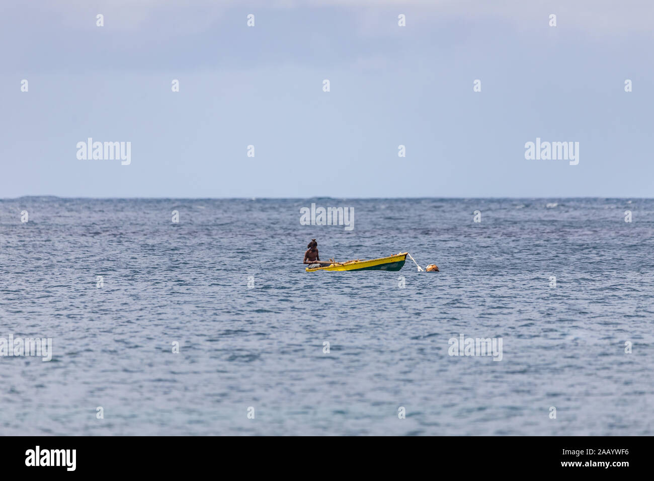 Saint Vincent e Grenadine, pescatore in barca a remi in barca in legno Foto Stock