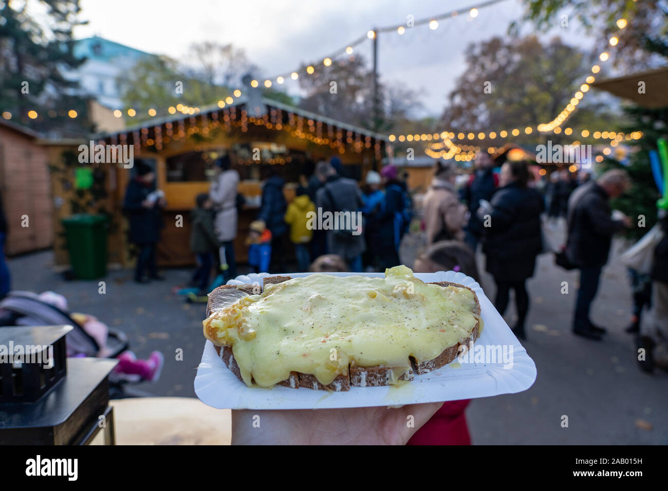 Natale tradizionale mercato invernale di alimenti in Germania Svizzera e Austria formaggio raclette su una fetta di pane Foto Stock