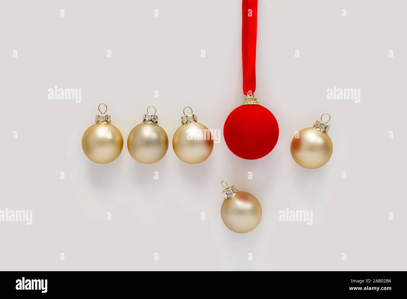 Rosso grande palla di Natale spinge una piccola palla dorata. Foto Stock
