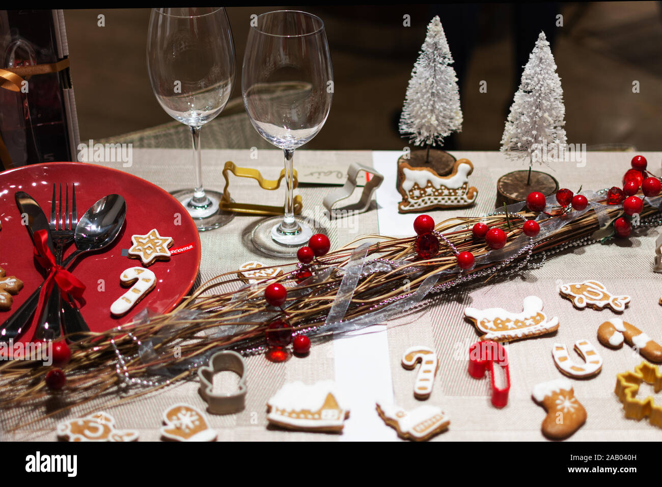 Natale messa in tavola con biscotti allo zenzero e holly bacche decorazioni. Vacanze di Natale decorazioni tavola. Foto Stock