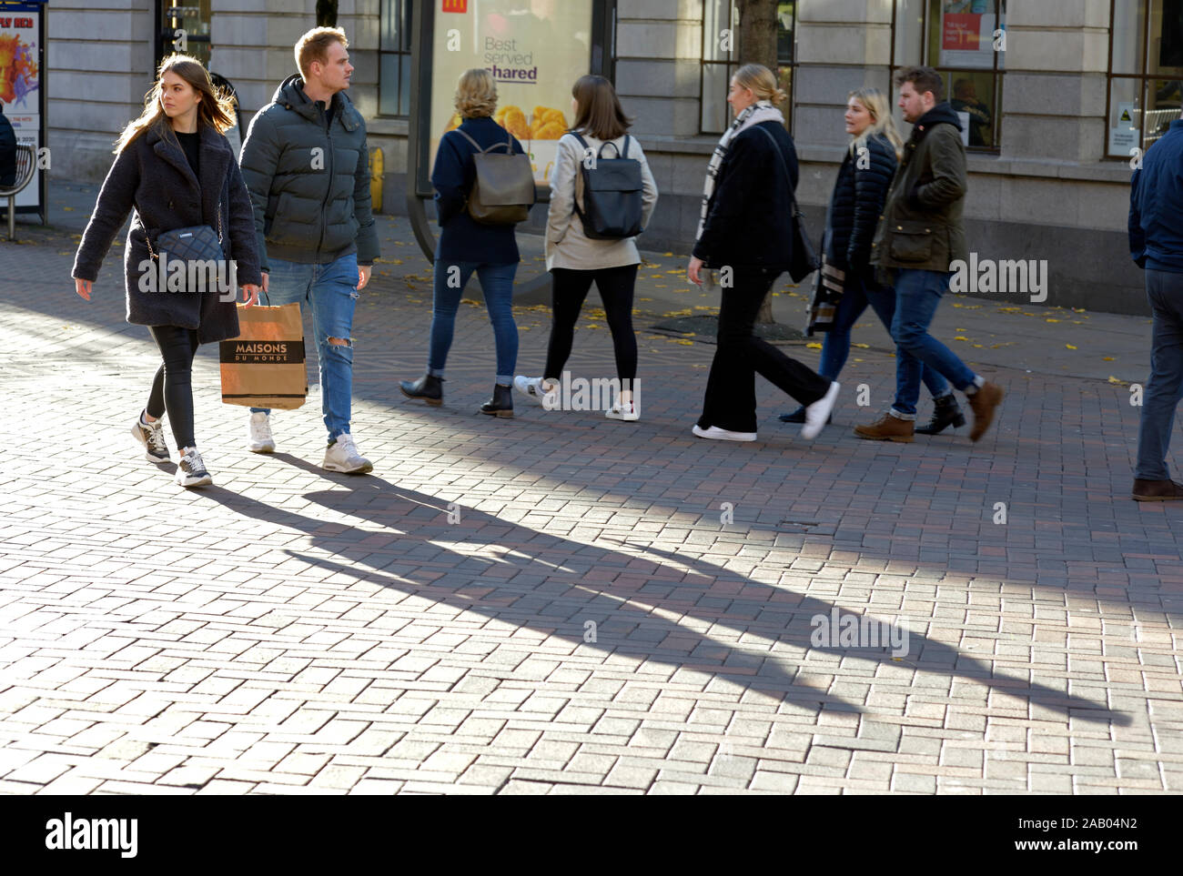 La gente fuori shopping a Nottingham, ombre lunghe Foto Stock