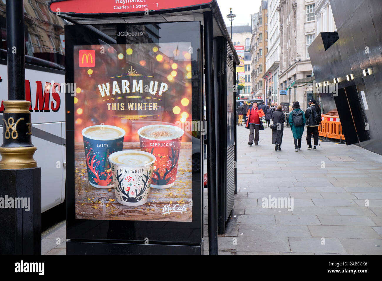 Bus McCafe shelter pubblicità che mostra le bevande calde e slogan Warm up, nel centro di Londra Foto Stock