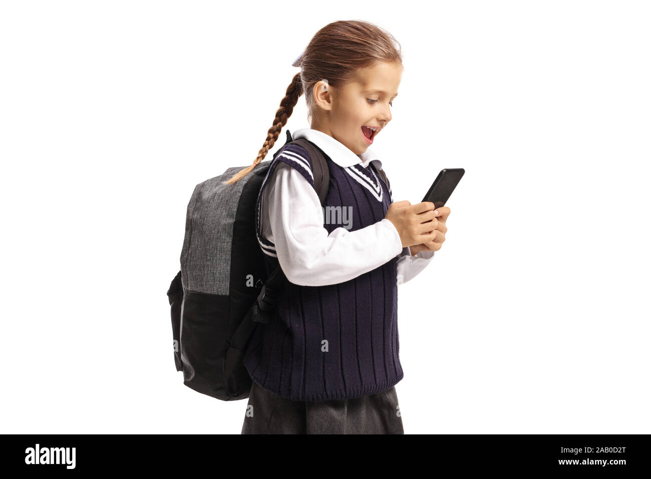 Happy Little Schoolgirl tenendo un telefono cellulare isolato su sfondo bianco Foto Stock