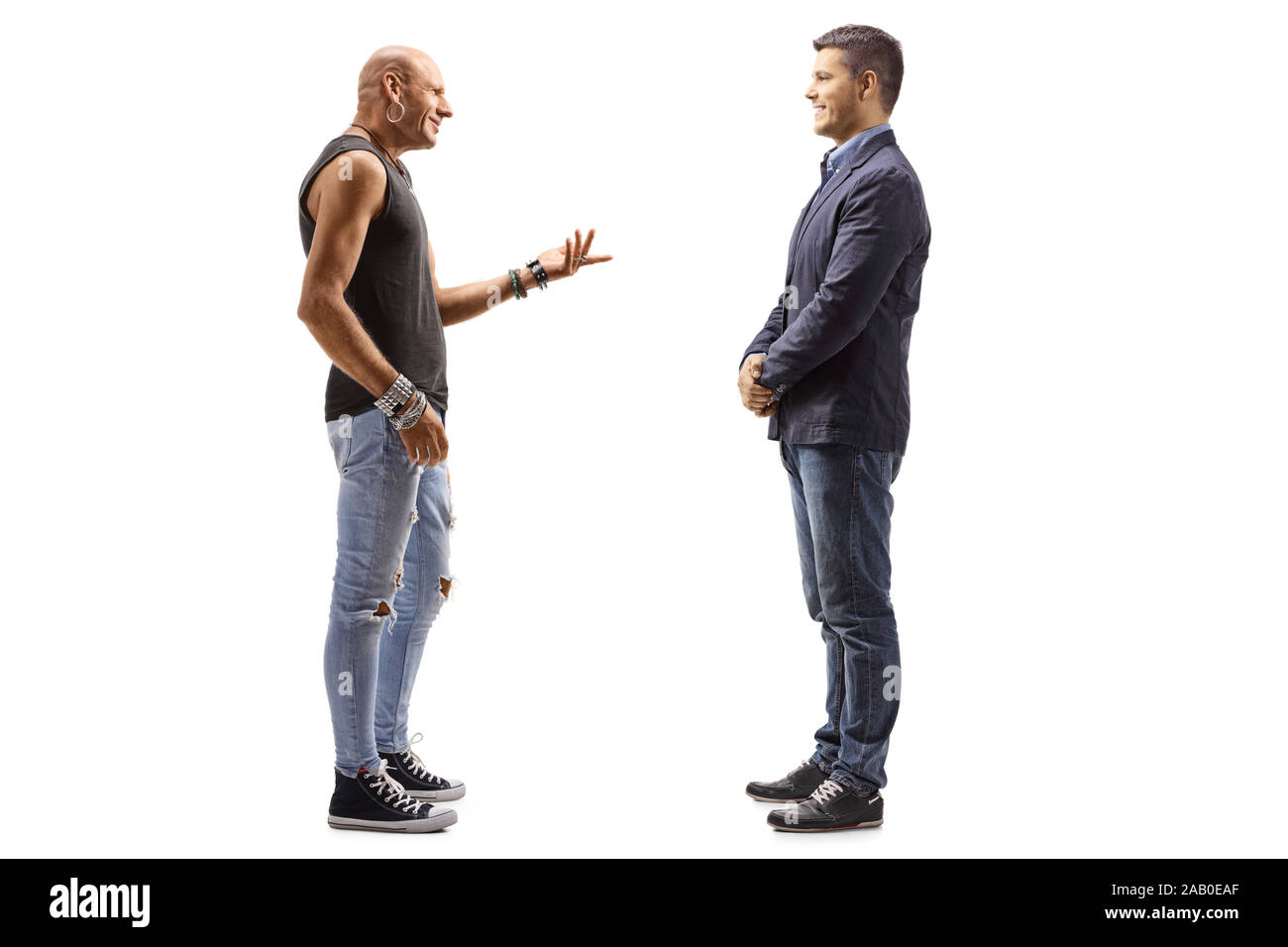 Lunghezza piena ripresa di profilo di un maschio hipster parlando a un giovane ragazzo isolato su sfondo bianco Foto Stock
