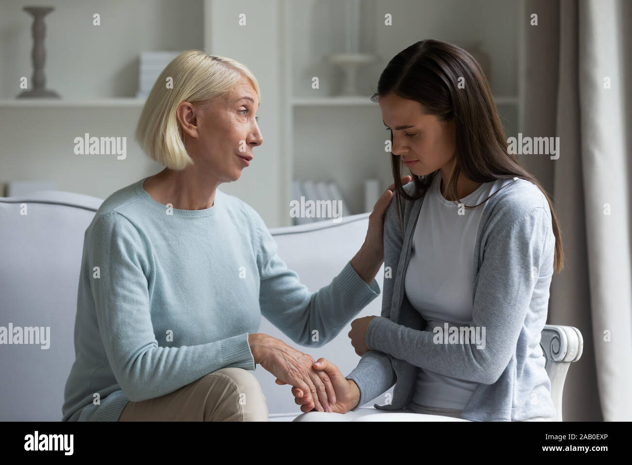 60s mom calmante figlia cresciuto dando sostegno che mostra care Foto Stock
