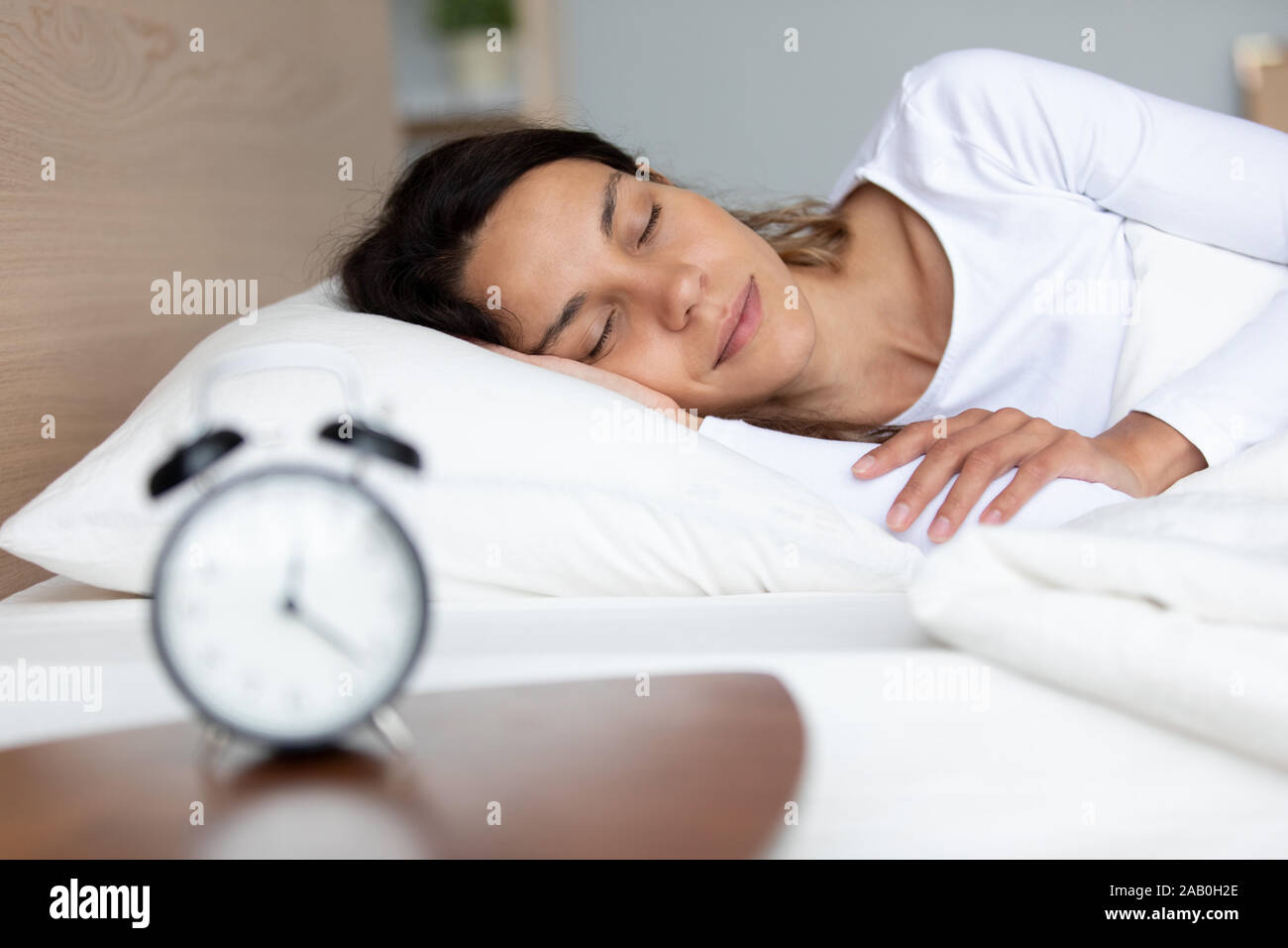 Sleeping giovane donna gustare fresche lenzuola e sogni dolci Foto Stock