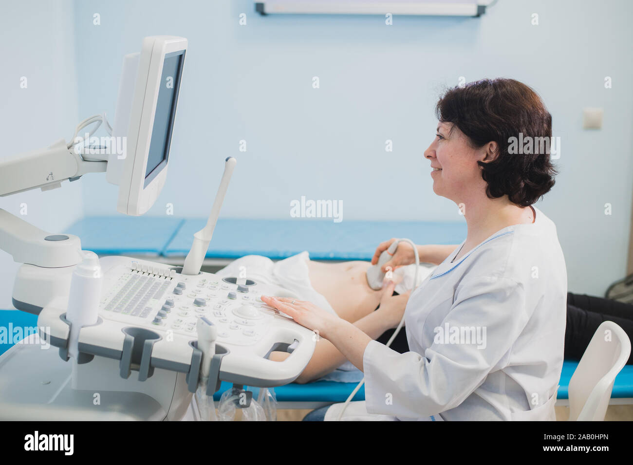 Medico di eseguire una scansione ad ultrasuoni sulla donna in stato di gravidanza Foto Stock