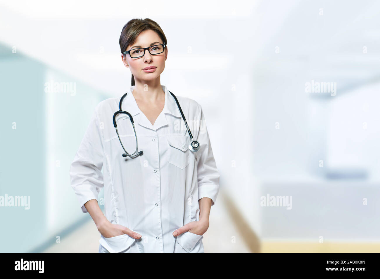 Ritratto di grave medico con stetoscopio guardando la fotocamera.medico medico medico donna blu su sfondo clinica Foto Stock