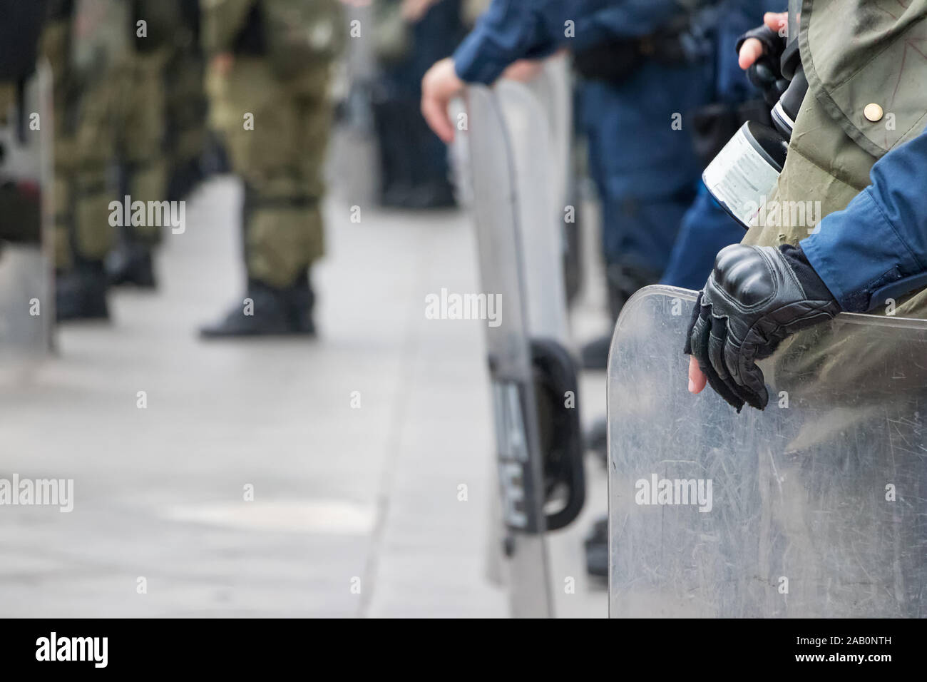 Maschio di polizia antisommossa tenendo la sua protezione con la sua mano. Foto Stock