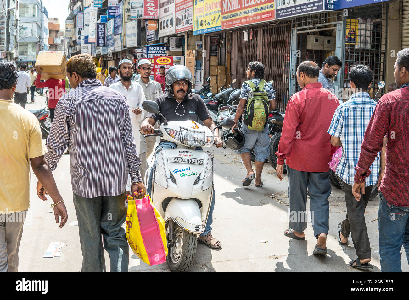 Città Bengaluru, Sadar Patrappa Road, locale mercato elettronico con computer, Induisti indiani facendo shopping, stretta strada affollata Foto Stock