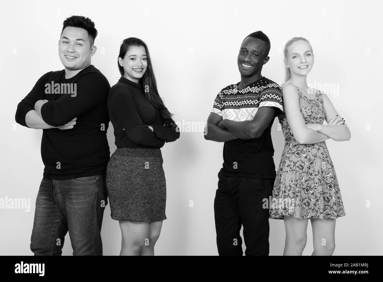 Studio shot di felice variegato gruppo di multi etnico amici sorridente con le braccia incrociate insieme dorso a dorso Foto Stock