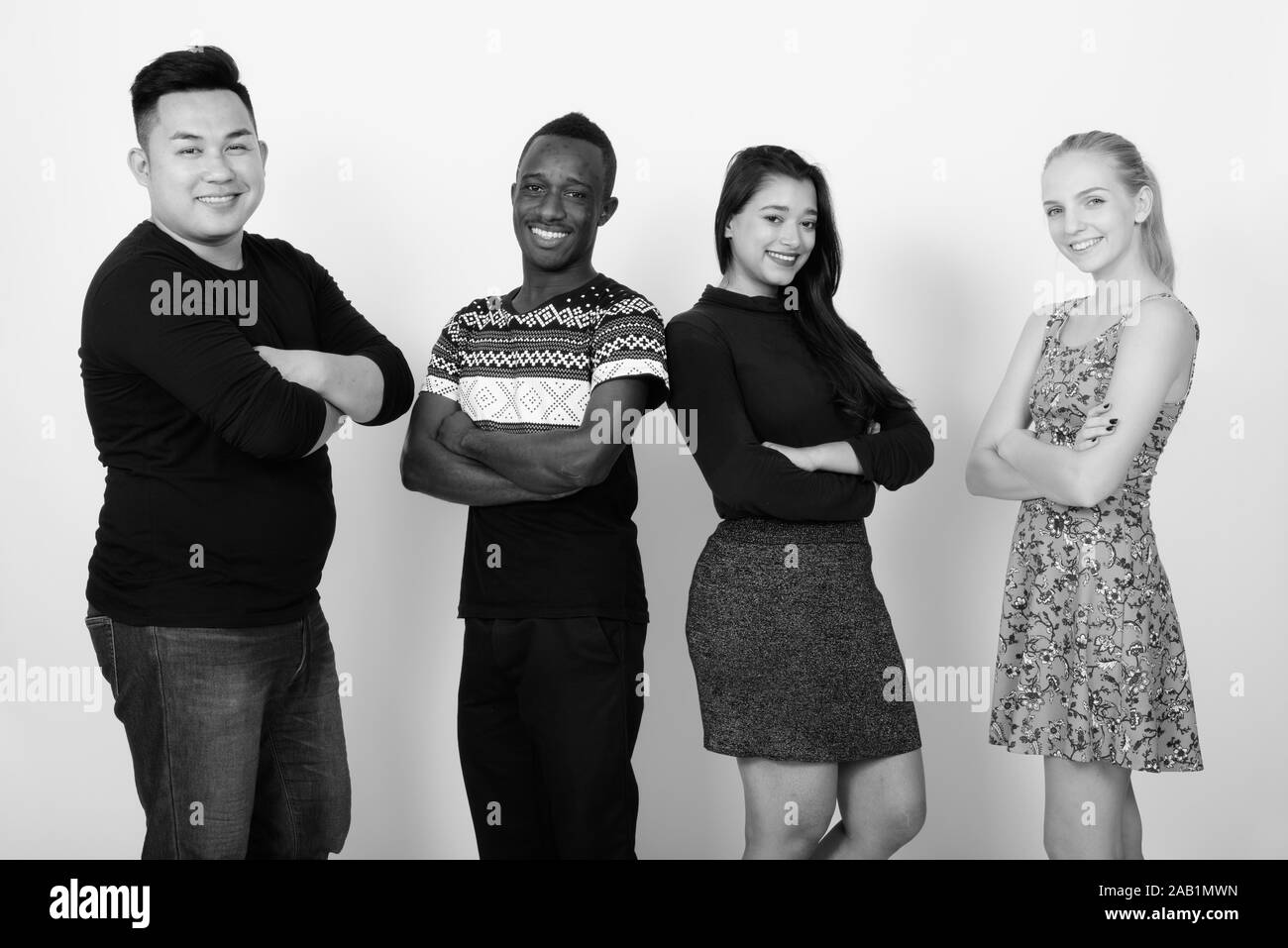 Studio shot di felice variegato gruppo di multi etnico amici sorridente con le braccia incrociate mentre tra loro affacciate Foto Stock