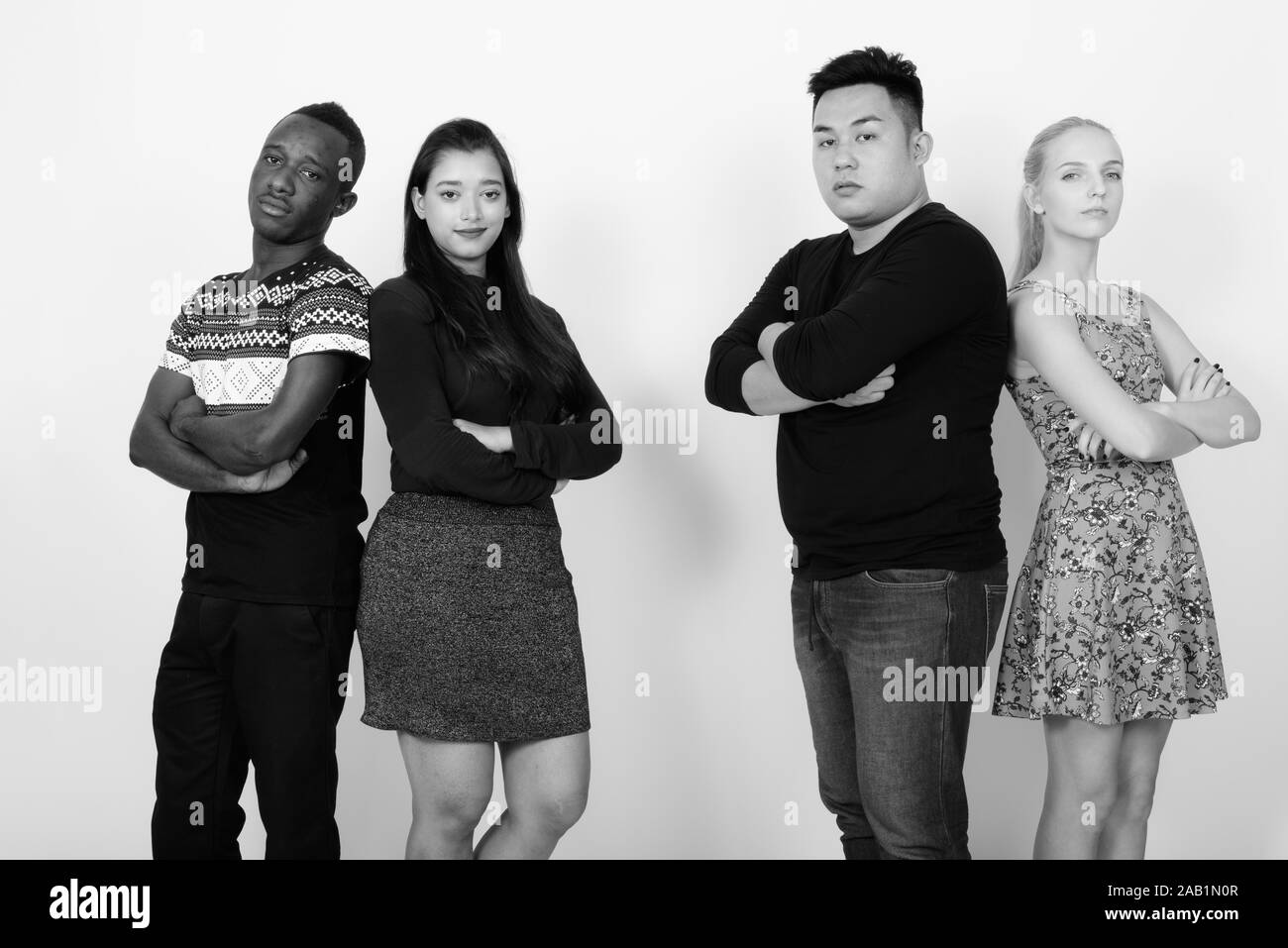 Gruppo diversificato di multi etnico amici con le braccia incrociate insieme dorso a dorso Foto Stock