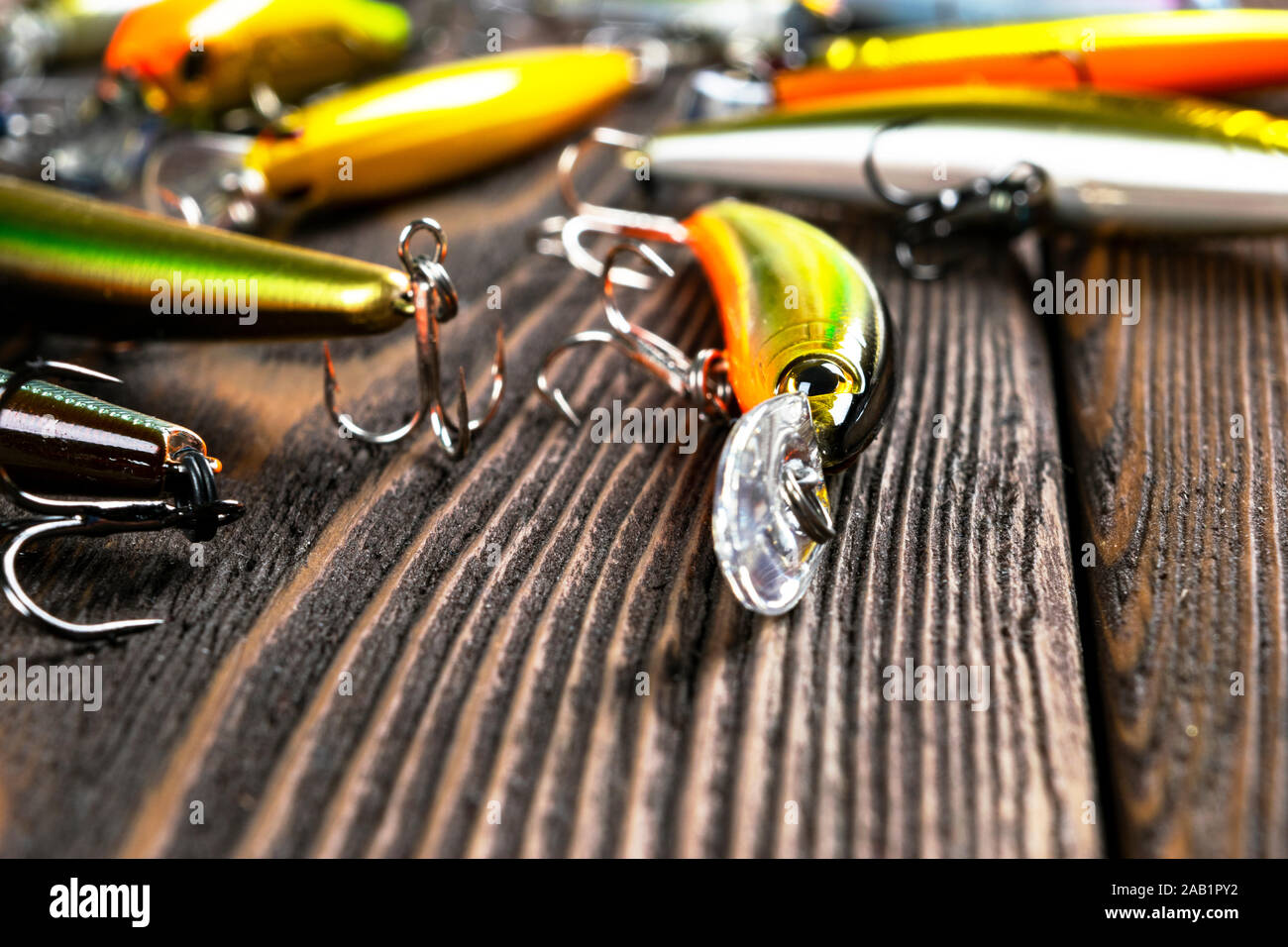 La pesca dello sfondo. La pesca affronta e wobbler sulla tavola di legno. Ami da pesca, esche e esche. Attrezzi di pesca al buio su un tavolo Foto Stock