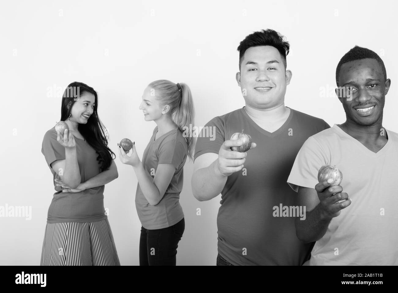 Felice gruppo diversificato di multi etnico sorridente amici tenendo red apple insieme con gli amici a parlare nel retro Foto Stock