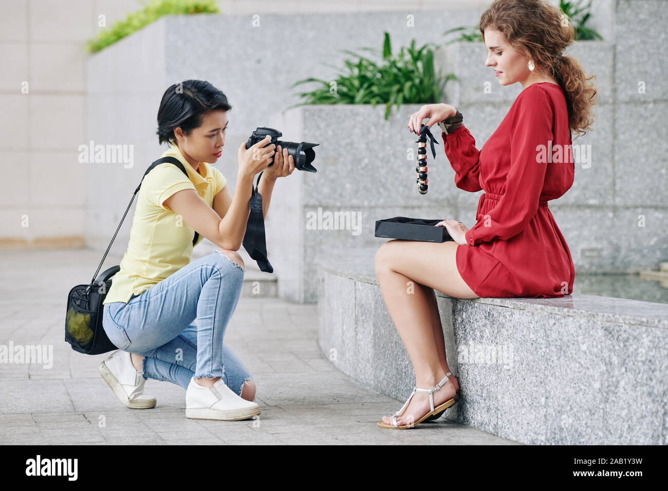 Piuttosto giovane donna prendendo enorme collana fuori giftbox e in posa per una foto Foto Stock