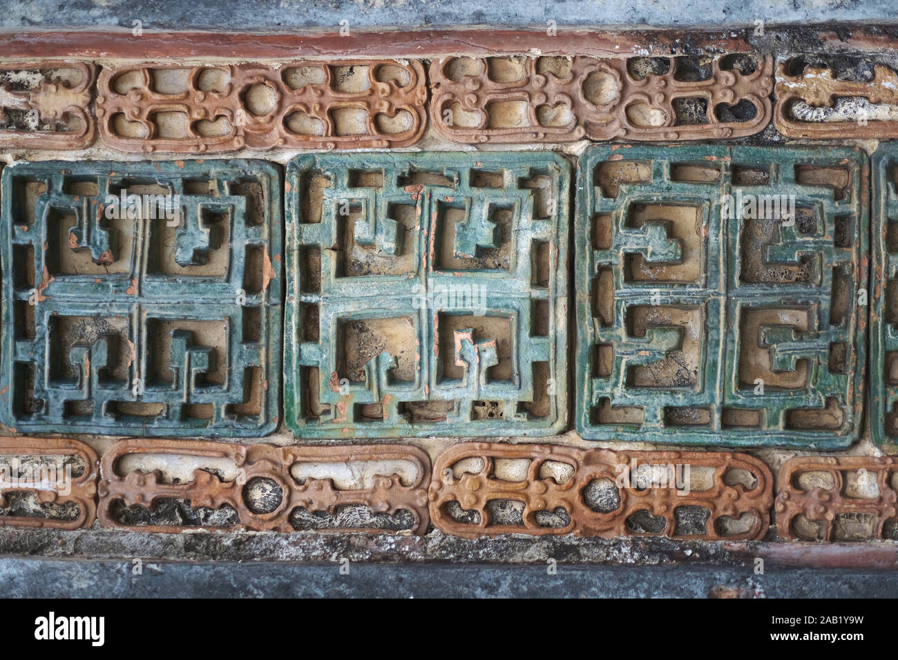 Frammento di un vecchio muro con un antico elemento decorativo. Il Vietnam. Foto Stock Frammento di un vecchio muro con un antico elemento decorativo. Il Vietnam. Foto Stock